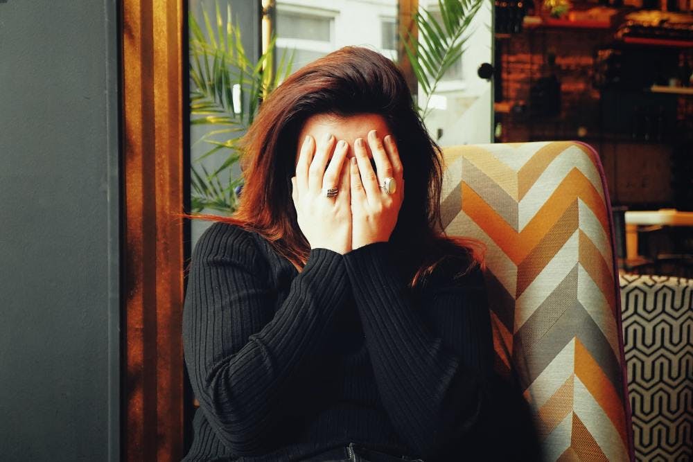Stressed women with her hands in front of her face