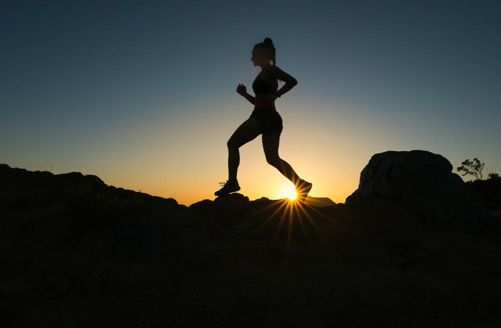 Person running in front of sunrise