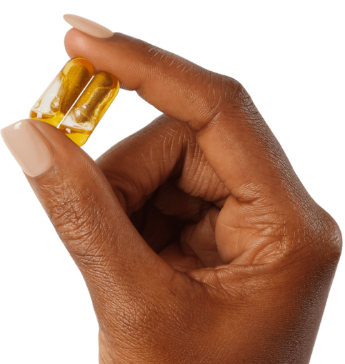 A hand holding two Smart Supplement pills